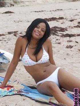Beautiful young ebony Nina Belle with big tits sunning on the beach in bikini