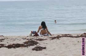 Beautiful young ebony Nina Belle with big tits sunning on the beach in bikini