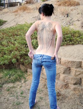 Slutty brunette teen with tattoos and natural tits Daisy Cums posing outdoors