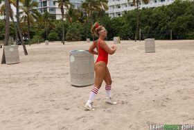 Hot blonde lifeguard with bubble butt Kelsi Monroe stretching on the beach