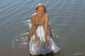 White teen Mak heads into the water with an air mattress while totally naked