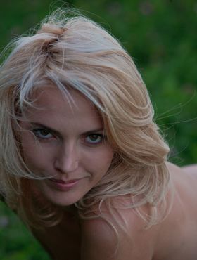 Sexy blonde teen Lilly A models naked in the grasses alongside a river