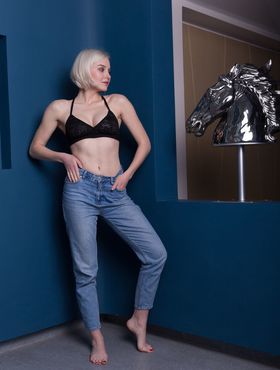 Young blonde Natalie P removes her bra and blue jeans to model in the nude