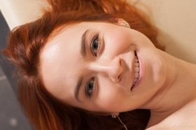 Young redhead Kelly G takes off mesh stockings to model totally naked