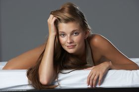 Young Russian girl with a nice smile poses her tan lined body in the nude