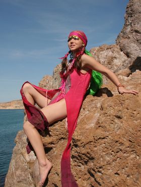 European teen Firebird A posing barefoot on rocky cliffs in revealing outfit