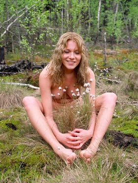 Barefoot girl with firm tits and erect nipples wanders around marshy ground