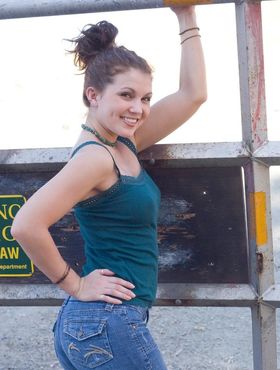 Young white girl Stella poses in the nude up against barb wire fence