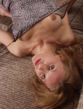 Solo girl with blonde hair strikes great poses while getting naked on couch