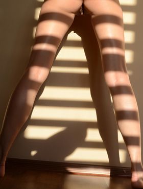 Naked teen girl Belinda B models in light filtered by a window blind