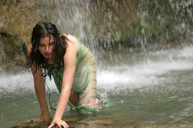 Solo girl with a hairy muff gets soaking wet underneath a waterfall
