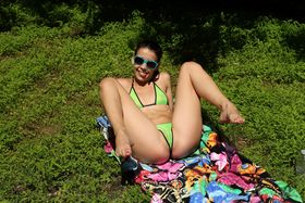 Dark haired teen Alaina Kristar dildos her pussy atop a towel on the lawn
