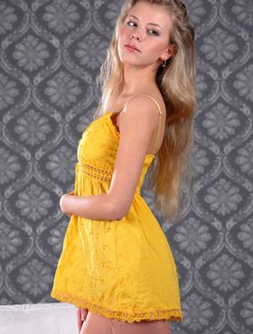Coy model Barbara D doffs her yellow dress to reveal a smooth shaved pussy
