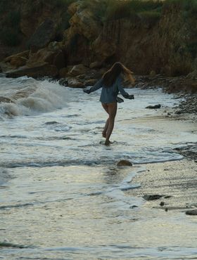 Nice teen girl Petra E removes her shirt after wading out into the ocean