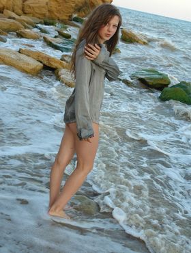 Nice teen girl Petra E removes her shirt after wading out into the ocean