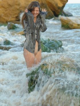 Nice teen girl Petra E removes her shirt after wading out into the ocean