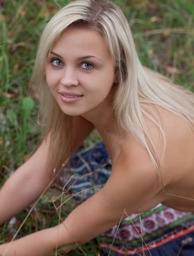 Attractive blonde Luciana romping naked in the long grass showing tits and ass