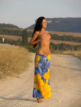 Gorgeous model Macy B drops her sarong to pose on the road with tiny tits bare