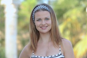 Teen solo girl Odara wears her hair back while peeling off one piece swimsuit