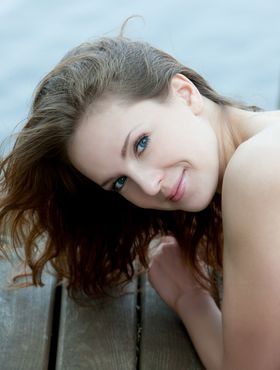 Euro model Ilze wears a smile on pretty face during nude posing on dock