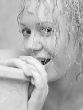 Redhead with curly hair gets wet while taking off her clothes in the shower