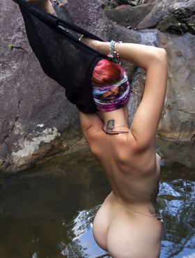 Teen girl with dyed hair Leocadia gets totally naked in a pool below waterfall