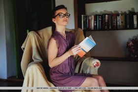 Thin teen takes off her glasses before modeling naked after reading in a chair