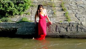 Busty brunette in red dress and exotic panties goes for a swim in local river