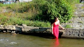 Busty brunette in red dress and exotic panties goes for a swim in local river