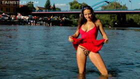 Busty brunette in red dress and exotic panties goes for a swim in local river