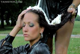 Two clothed females completely cover each other with whip cream in public park