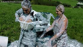 Fully clothed fashionistas have some messy and slimy fun outdoor