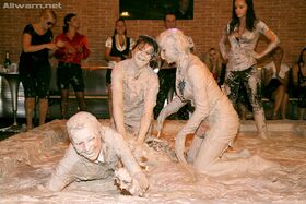 Fully clothed fetish lassies enjoy a messy catfight in the mud