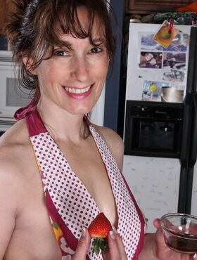 Middle-aged lady Celeste Carpenter takes off her apron to pose nude in kitchen