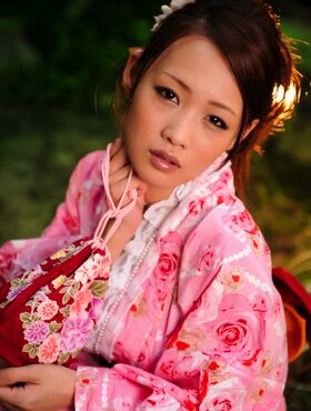 Cute Asian geisha teases in her bright pink kimono