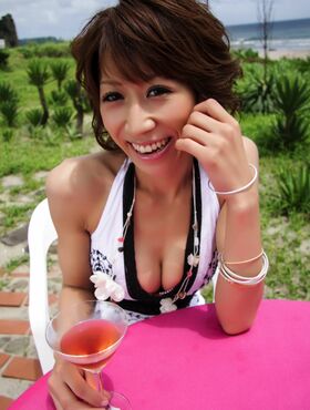 Fun Asian hottie drinks a martini outdoors