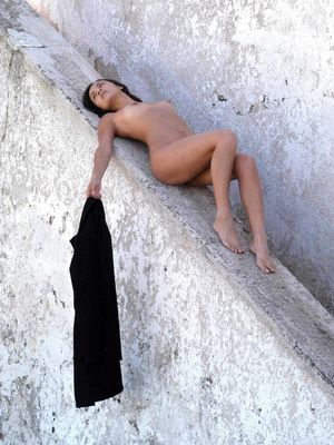 The Life Erotic - Barefoot beauty with an ass to die for lays flat naked on stone railing